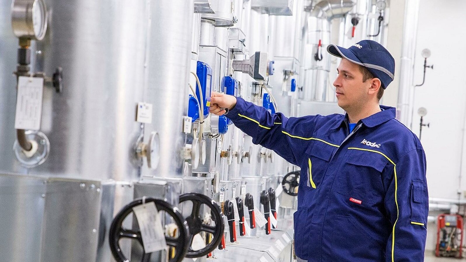 Leadec employee working at a pipe system for the utilities.