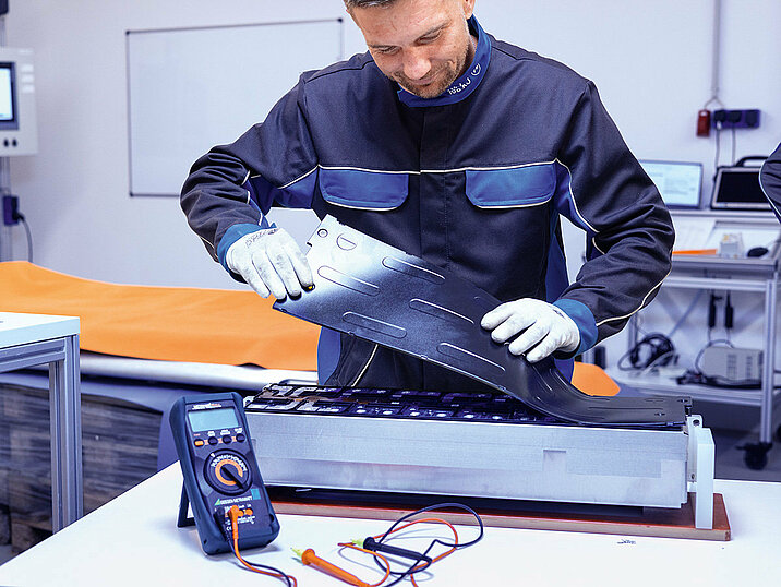 Leadec employee checking the module voltage of a battery.