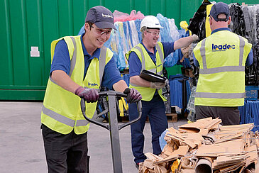 A Leadec employee with a pallet of paper waste at a waste yard.